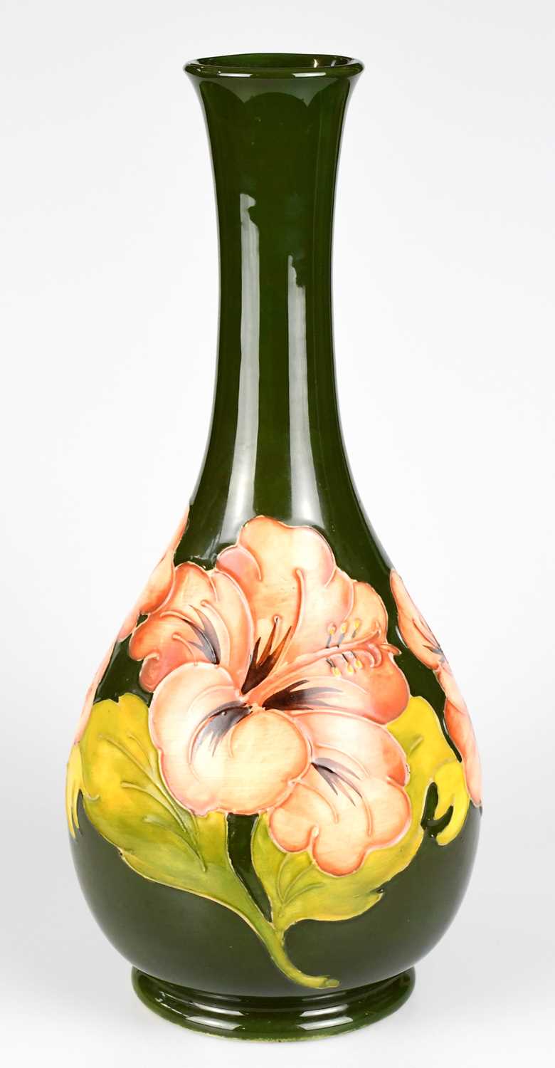 MOORCROFT; a baluster shaped vase decorated in the 'Coral Hibiscus' pattern on a green ground,