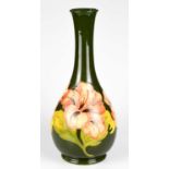 MOORCROFT; a baluster shaped vase decorated in the 'Coral Hibiscus' pattern on a green ground,