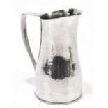 KESWICK SCHOOL OF INDUSTRIAL ARTS; a hammered pewter jug, with impressed marks and shape number