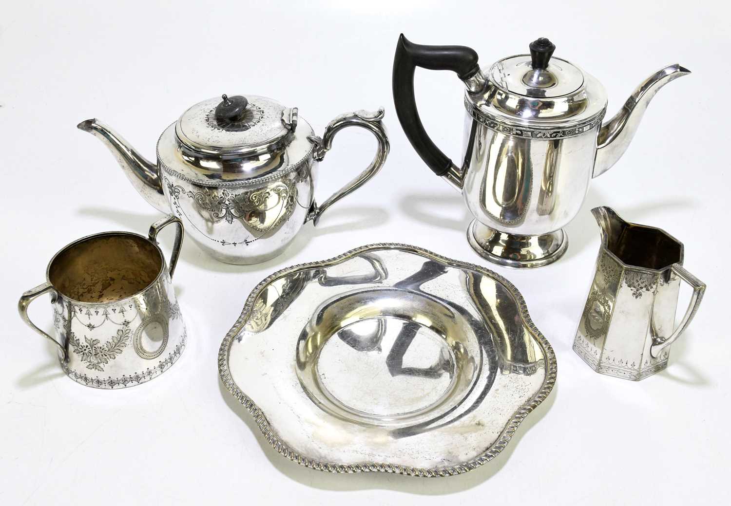 Two silver plated teapots with a sugar bowl, a cream jug and a dish.