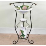 A modern wrought iron and pottery washstand with floral decorated bowl, soap dish, and water jug,