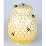 SALLY TUFFIN FOR DENNIS CHINAWORKS; a jar and cover, relief decorated with bees on honeycomb,