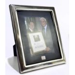 An Elizabeth II hallmarked silver photograph frame inscribed to the border 'Noel, Tribute Dinner