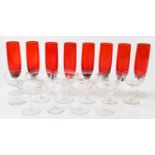 A set of eight red and clear glass champagne flutes, height 21cm, with ten assorted champagne