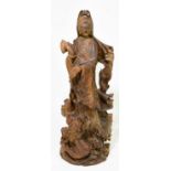 A Japanese carved hard wood figure of Guanyin, standing upon a rock with a dragon below, height