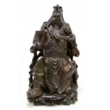 A Japanese carved hard wood figure of a seated warrior reading from a book, height 30cm.