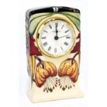 NICOLA SLANEY FOR MOORCROFT; a mantel clock decorated in the 'Anna Lily' pattern, height 15cm.