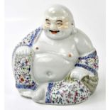 A Chinese Famille Rose porcelain model of a seated Buddha, his robe with floral decoration,