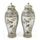 A pair of Chinese Republic period Famille Rose ovoid vases and covers, each painted with opposing