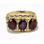 A 9ct yellow gold and garnet three stone ring, size M 1/2, approx. 3.6g.