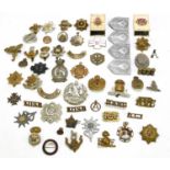 A collection of assorted cap badges, various regiments to include Warwickshire, The Lancashire