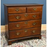 An early 19th century oak chest, with two short and three long drawers, on bracket feet, height