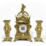 A late 19th century century brass clock, decorated with a cherub playing horn, together with