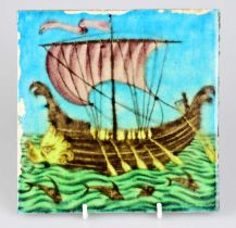 WILLIAM DE MORGAN; an Art Pottery tile painted with a galleon ship and five sailors with paddles,