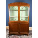 A 19th century mahogany bookcase with arched top above the pair of astragal glazed doors,