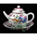 An 18th century Chinese Famille Rose teapot and stand painted in enamels with floral decoration,