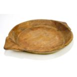 A rustic shallow wooden bowl with shaped handles, width 58cm.