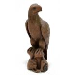 A Japanese carved hard wood model of an eagle perched upon a rock, height 28.5cm.