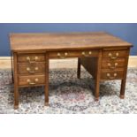 An early 20th century oak twin pedestal desk with central drawer and three further drawers to either