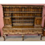 An 18th century style Shropshire design oak dresser, the raised back with four open shelves and