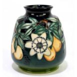 MOORCROFT; a squat vase of tapering form decorated in the 'Passionfruit' pattern on a green