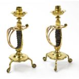 A pair of brass candlesticks fashioned from hilts of Victorian officers swords