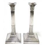 A pair of early 20th century Continental silver plated fluted Corinthian column candlesticks, on