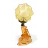 An Art Deco amber coloured glass lamp and shade, modelled as woman, height including sahde 40cm.