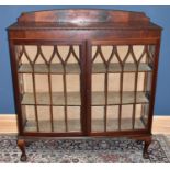 An Edwardian mahogany and pine display cabinet, with two astragal glazed doors, on claw and ball