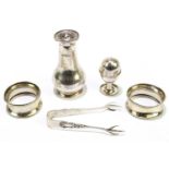 A small group of hallmarked silver items to include two napkin rings, sugar tongs and two salts,