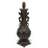 A Japanese bronze twin handled lamp of baluster form, relief decorated with creatures climbing the