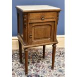 A late 19th century French oak bedside potcupboard, with marble top, drawer and panelled door,