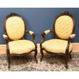 A pair of French carved and stained walnut Louis XV style chairs, the upholstery decorated with