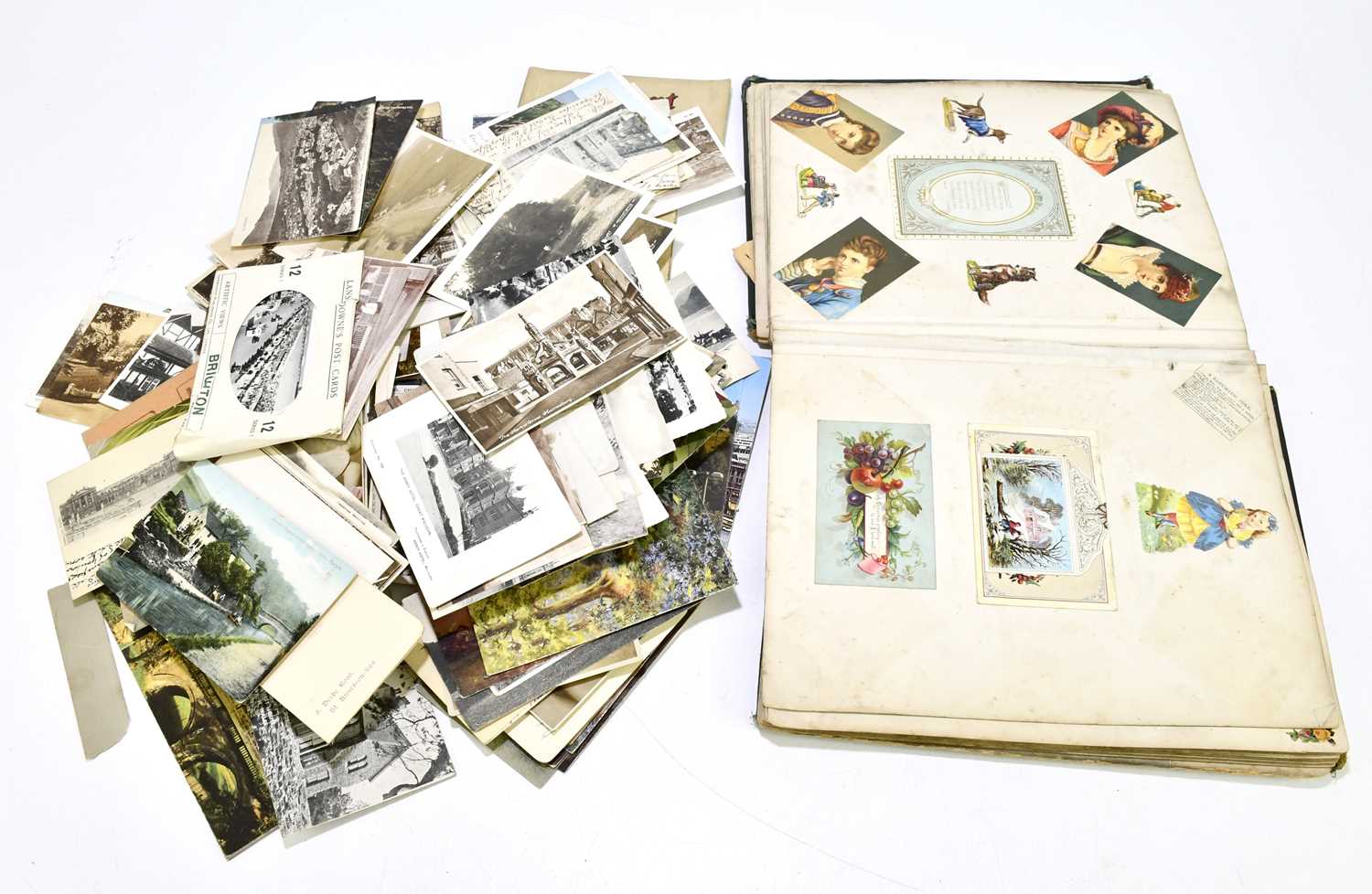 A late 19th/early 20th century scrapbook album containing various postcards and images, together