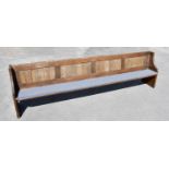 A large oak pew, with panelled back and solid seat, on standard end supports, height 84cm, length