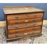 An Edwardian stained walnut plan chest, with five long drawers, each with a pierced brass cusped