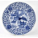 An early 20th century Japanese blue and white footed dish in a Chinese style, decorated with figures