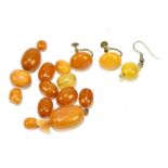 A group of loose amber beads and amber coloured beads, also a pair of screw back earrings,