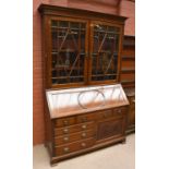 An Edwardian mahogany bureau bookcase of broad proportions, with two astragal glazed doors enclosing