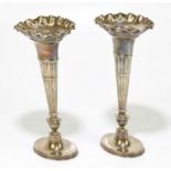 WALKER & HALL; a pair of Edward VII hallmarked silver posy vases with frilled rims and gadrooned