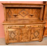 An 18th century style carved oak dresser, with two drawers and three panelled cupboard doors, height