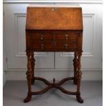 A reproduction walnut fall front bureau with two short over one long drawer, fitted interior, turned