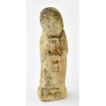 A carved stone figure of St Peter, possibly medieval, modelled with key, on a rectangular base,