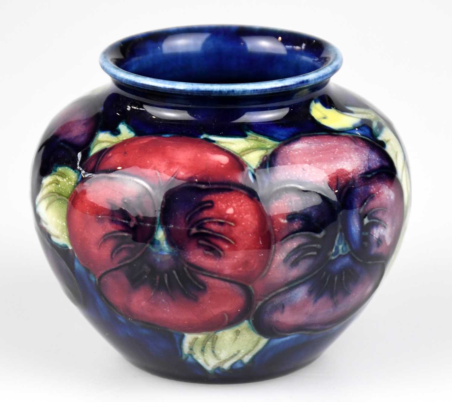 WALTER MOORCROFT; a squat vase in the 'Pansy' pattern on a blue ground, impressed marks to the