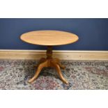 ERCOL; a light elm circular dining table, with turned column and outswept legs, height 73cm,