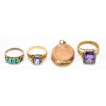 A yellow metal dress ring set with an emerald cut amethyst stone, and an open work setting with