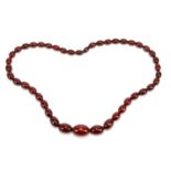 A single strand cherry amber bead necklace, the largest bead 3cm in length, length 37.5cm, weight