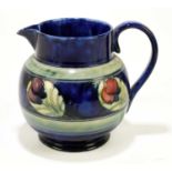 WILLIAM MOORCROFT; a bulbous jug decorated in the 'Wisteria' pattern on a blue ground, height 18cm.