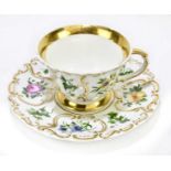 KPM BERLIN; a porcelain tea cup and saucer, with moulded detailing and hand painted with flowers,