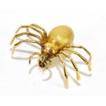 A yellow metal brooch in the form of a spider, with rubies for eyes, width approx. 42mm, stamped '